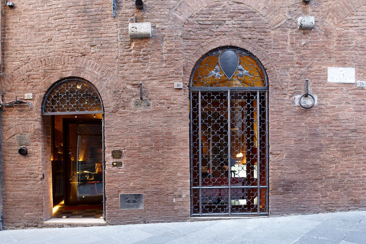 The arched stone entrance of the red-brick medieval palazzo, Palazzetto Rosso