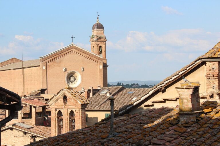 A rooftop view across Siena's rooftops to a church campanile, Palazzetto Rosso