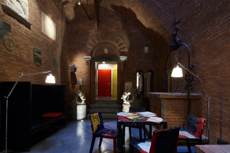A vaulted lounge with design seating and the signature red door, Palazzetto Rosso
