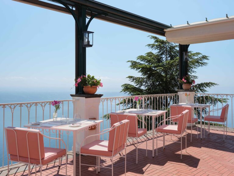 Terrace dining with coral chairs above the sea, Palazzo Avino