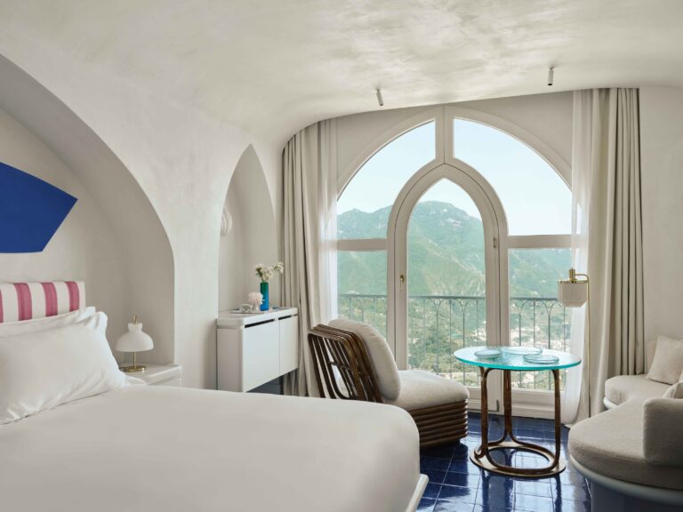 Bedroom with a striped headboard and an arched window, Palazzo Avino