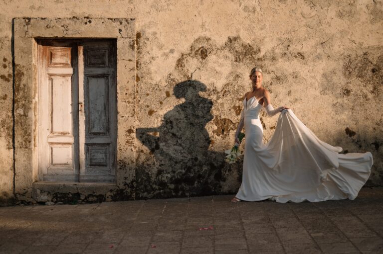 A weathered blue door, a lime-plaster wall, and a shadow thrown across the render, Pangiunìa Wedding