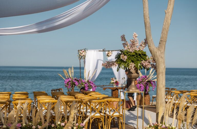 Seaside ceremony set-up with draped canopy and floral arrangements, Panta Rhei Wedding