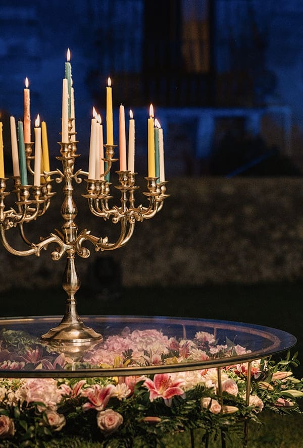 Candelabra with floating petals on a mirrored table