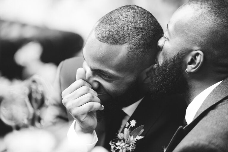 A close, unposed moment between two grooms, in black and white, Paola De Paola Photography