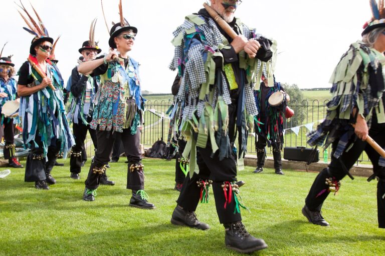 Morris dancers perform on the lawn at a barn wedding in the Cotswolds, Paola De Paola Photography