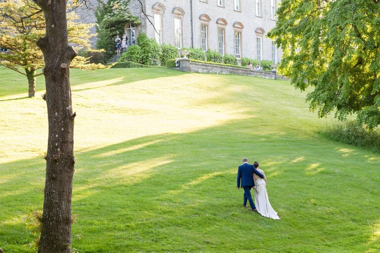 The couple walk up the lawn towards the house at Ston Easton Park, Somerset, Paola De Paola Photography