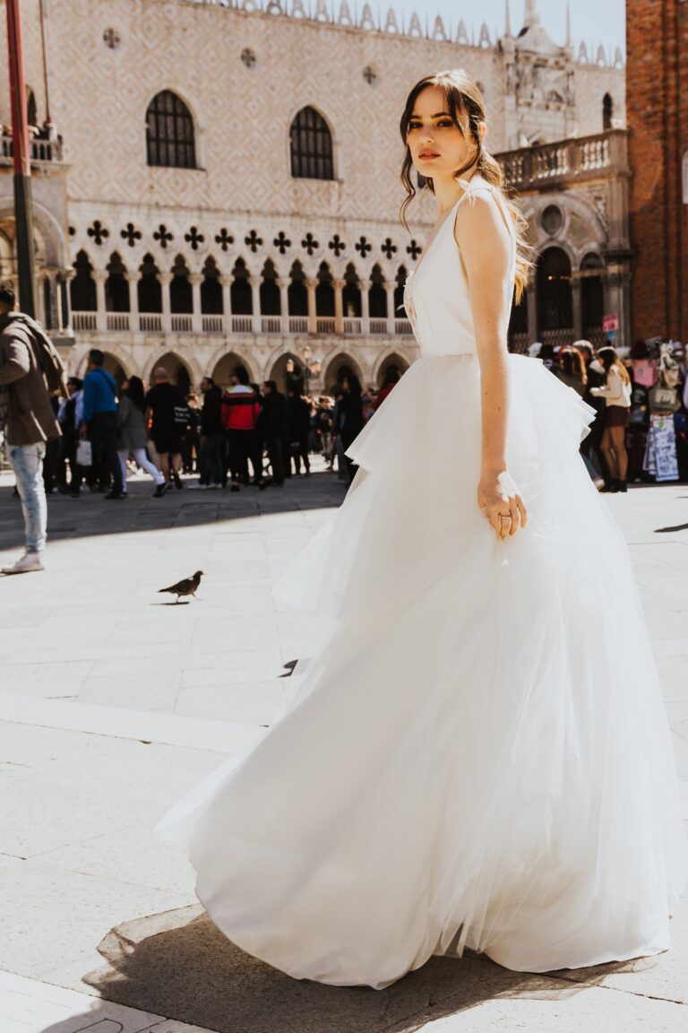 Bride in a tulle gown walking in front of the Doge's Palace in Venice, Paola Giancola Makeup