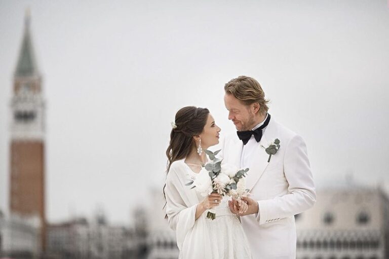 Bride and groom holding bouquets in front of the Campanile in Venice, Paola Giancola Makeup
