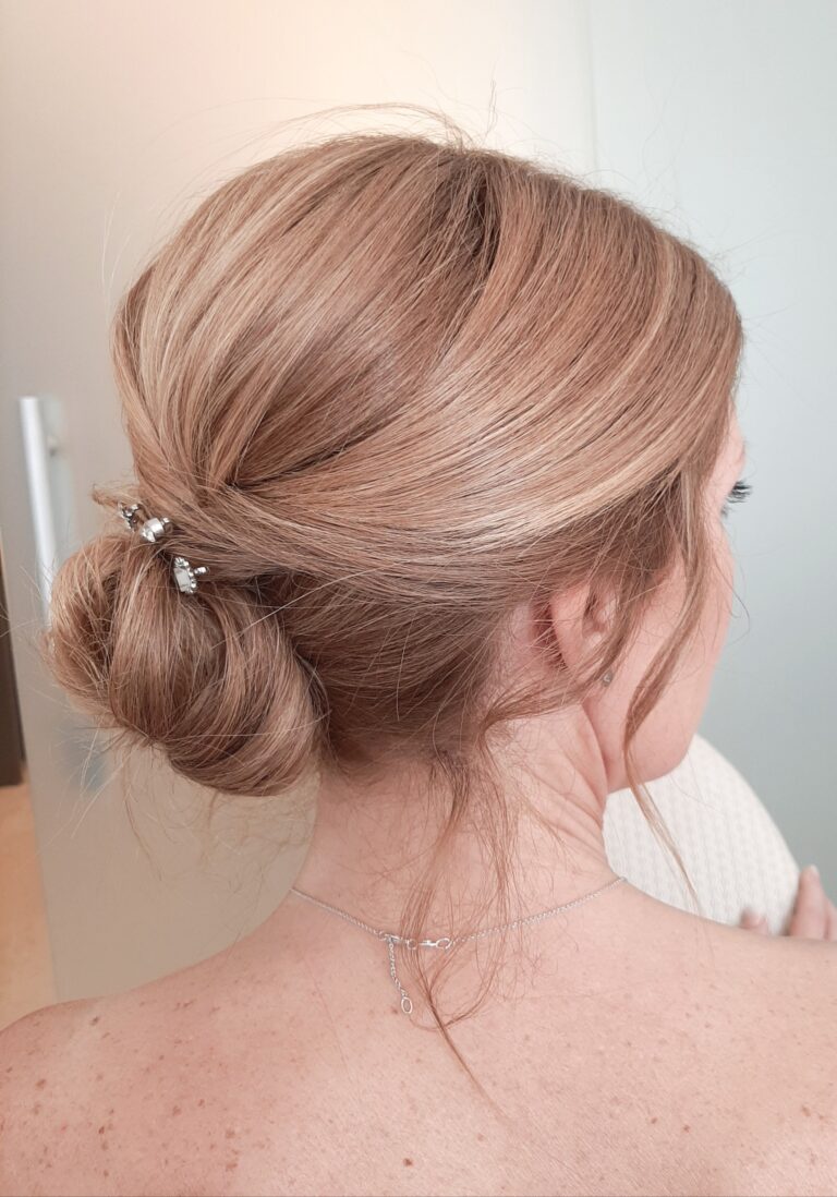 Low bridal chignon with a small clip, Paola Giancola Makeup
