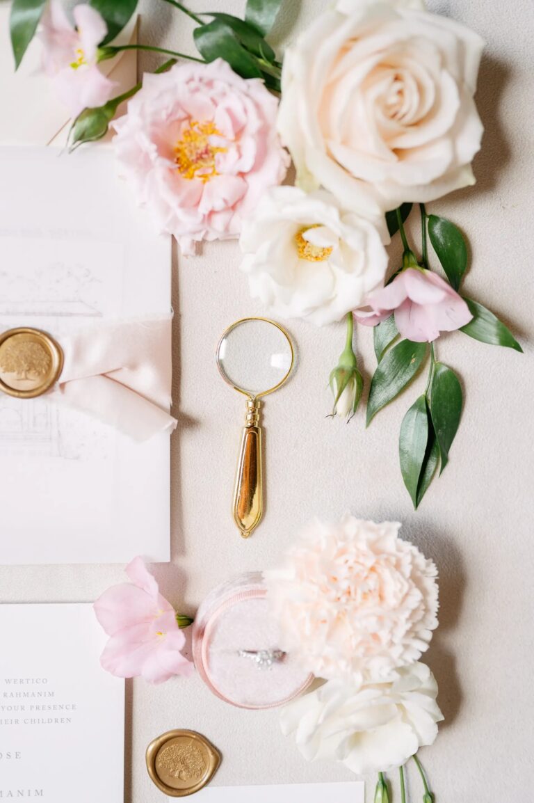 The same flat-lay up close, the magnifier between garden roses and a carnation, Paolo Cicognani Weddings & Events