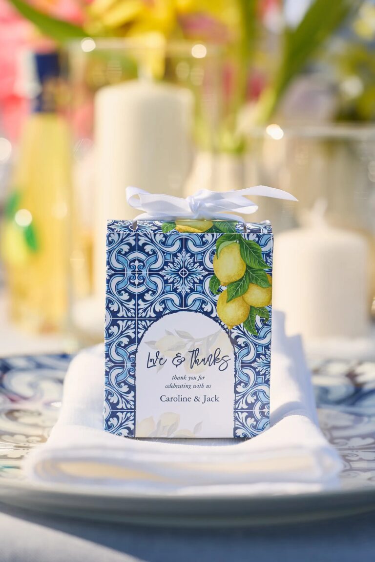 The favour box in blue tile and lemons, tied with white ribbon, on a folded napkin, Paolo Cicognani Weddings & Events