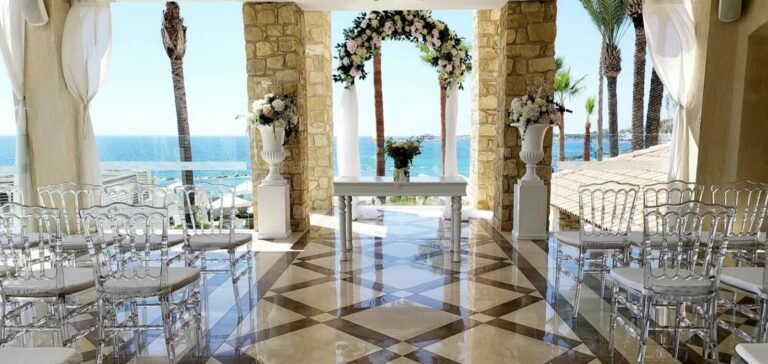 Stone pavilion ceremony set-up with a floral arch overlooking the sea, Alexander The Great Hotel, Paphos Weddings Made Easy