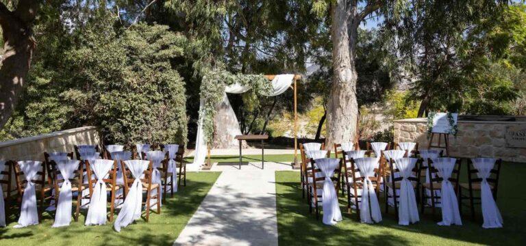 Ceremony chairs and a draped arch in the garden, Vasilias Traditional Inn, Paphos Weddings Made Easy