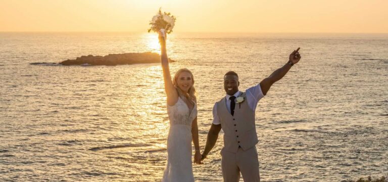 Newlyweds raising a bouquet against the sunset sea, Paliomonastiro, Paphos Weddings Made Easy