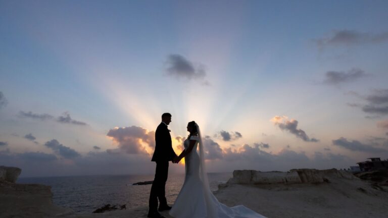 Couple silhouetted against a sunburst sky on the coast, Paliomonastiro, Paphos Weddings Made Easy