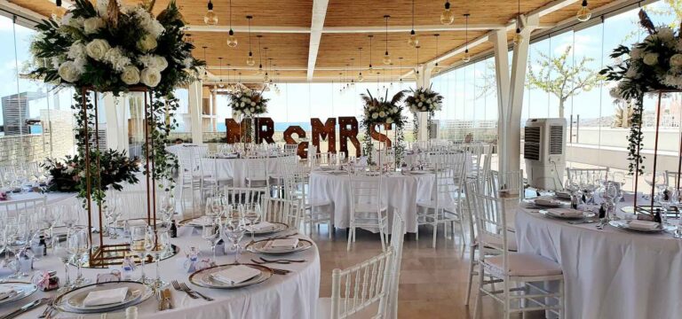 Reception tables beneath tall floral centrepieces and Mr and Mrs letters, Coral Residences, Paphos Weddings Made Easy