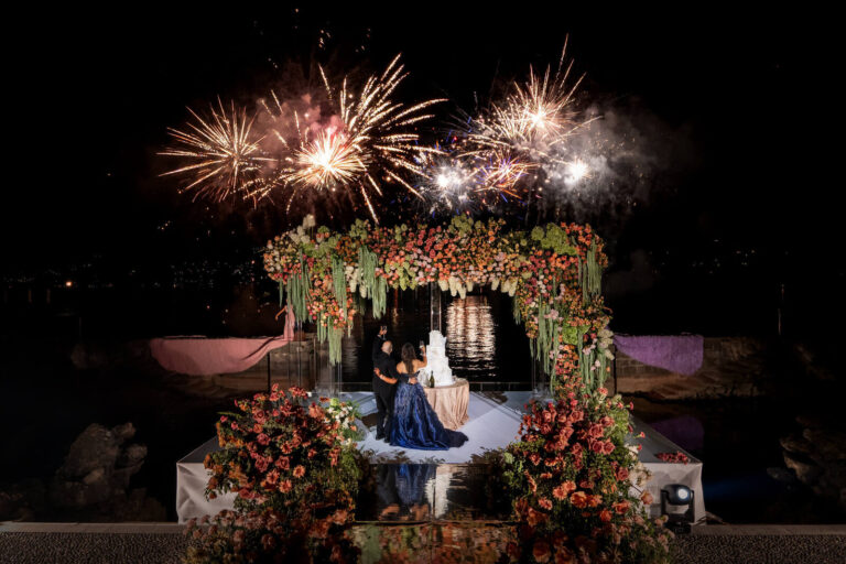Couple at a floral arch with fireworks over the lake at night, Patrizia Cilli Events Italy