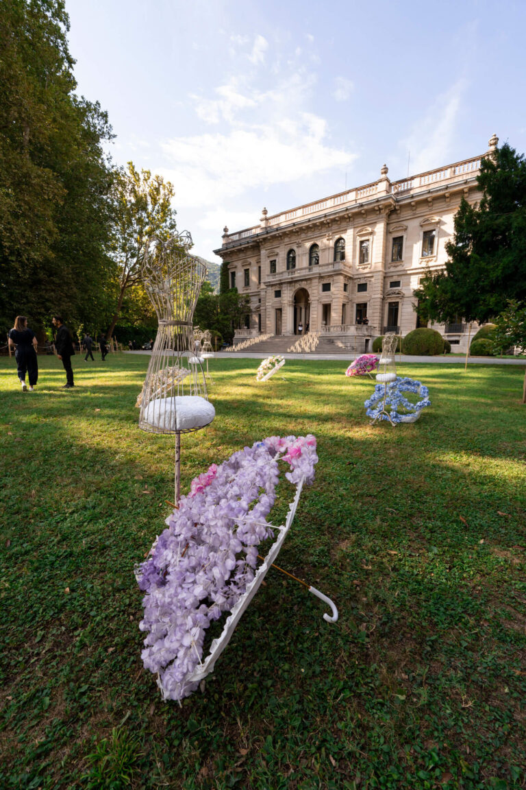 Floral umbrella sculpture on the lawn before a lakeside villa, Patrizia Cilli Events Italy
