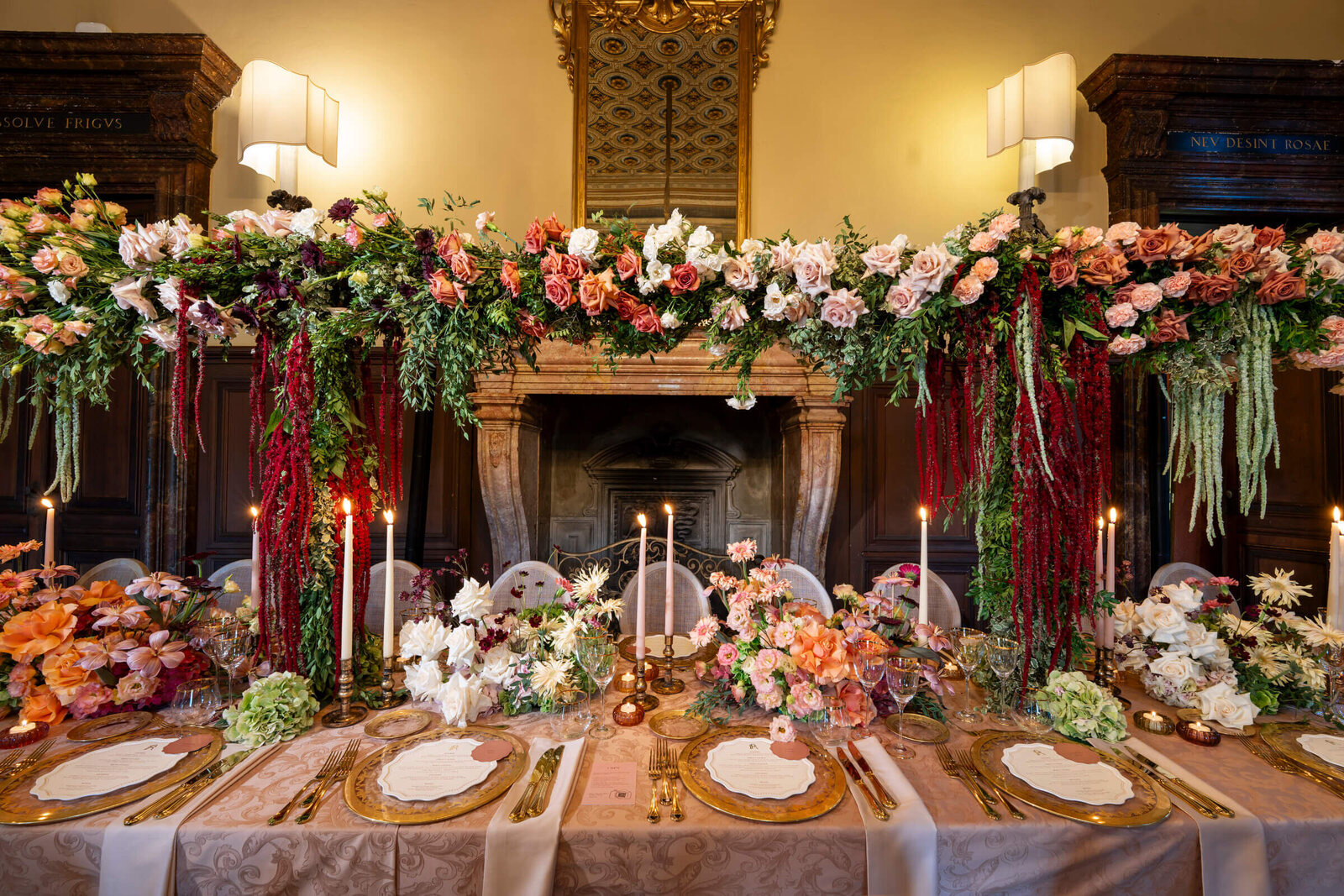 Floral-draped fireplace behind a long reception table in a historic villa room, Patrizia Cilli Events Italy