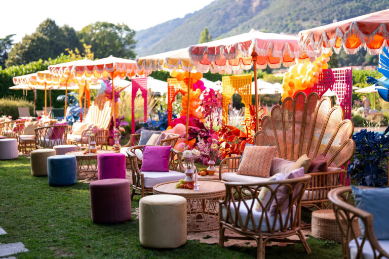 Colourful umbrella lounge with shell chairs and rattan seating in a lakeside garden, Patrizia Cilli Events Italy