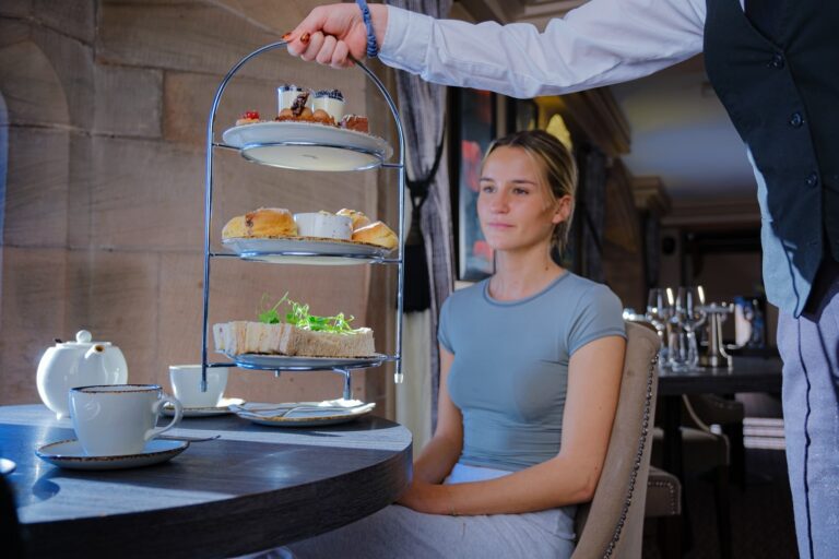 Afternoon tea served on a tiered stand in the castle restaurant, Peckforton Castle