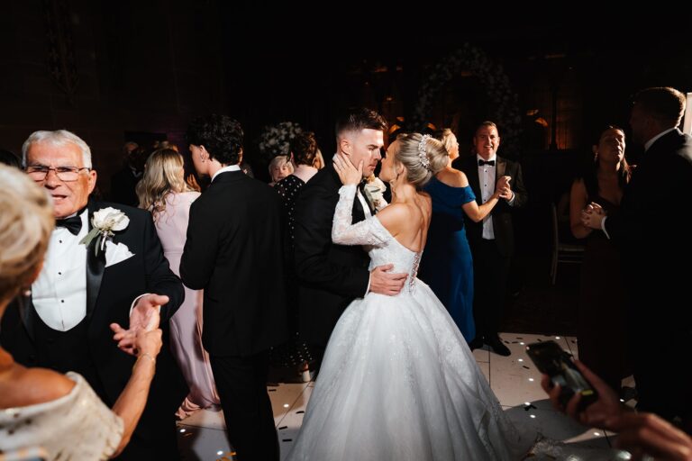 The couple's first dance among their guests on a sparkling dancefloor at night, Peckforton Castle