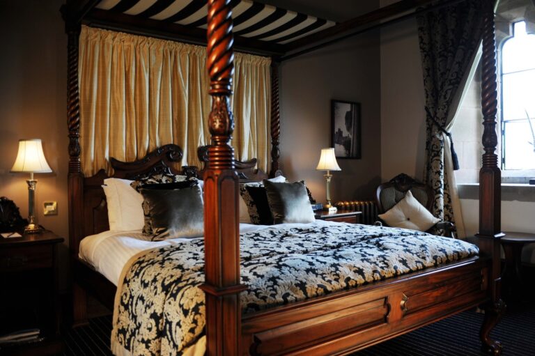 A four-poster bedroom dressed in gold and black damask, Peckforton Castle