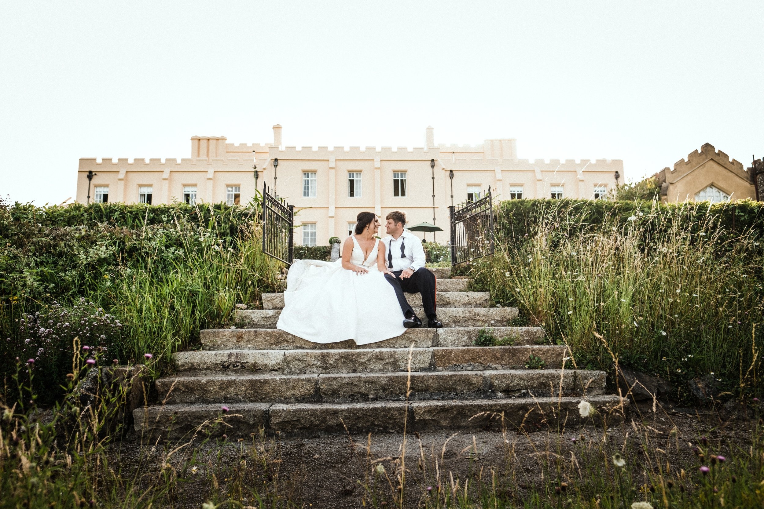 A couple on the stone steps before the castle, Pentillie Castle