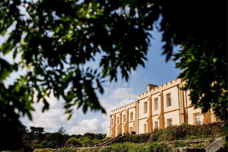 The castle framed by trees from the gardens, Pentillie Castle
