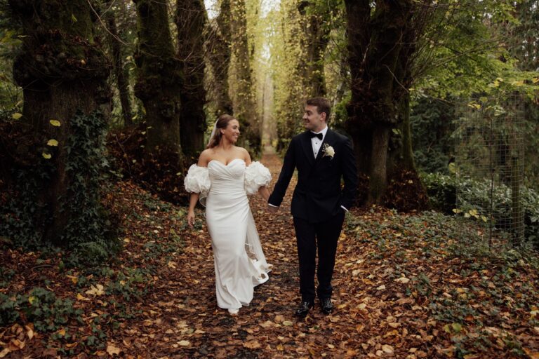 A couple walking in the autumn woods of the estate, Pentillie Castle