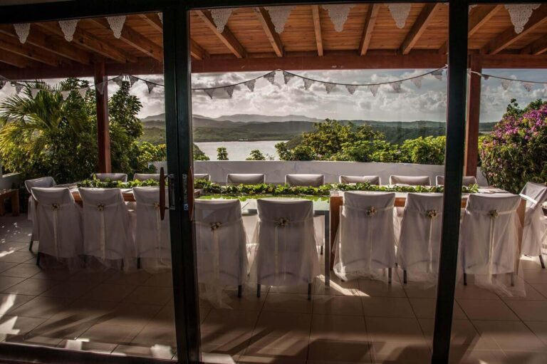 Dining table dressed with white chair covers and bunting on the covered veranda, Perfect Sunshine Antigua