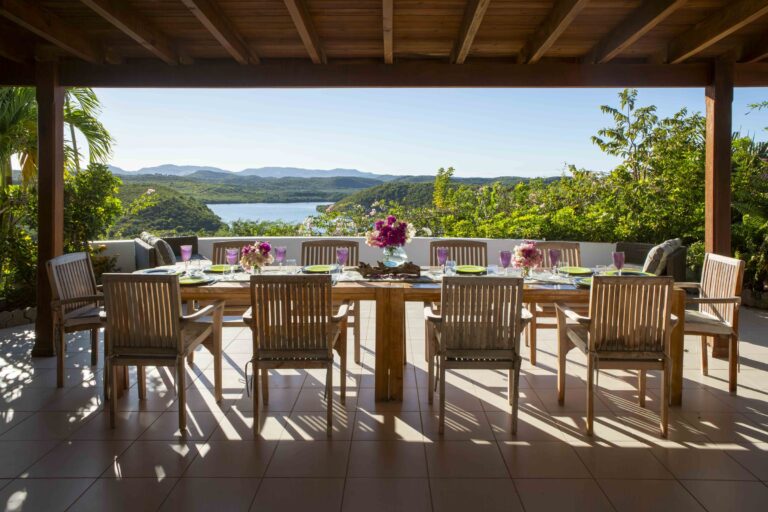 Dining table laid on the covered veranda with the bay beyond, Perfect Sunshine Antigua