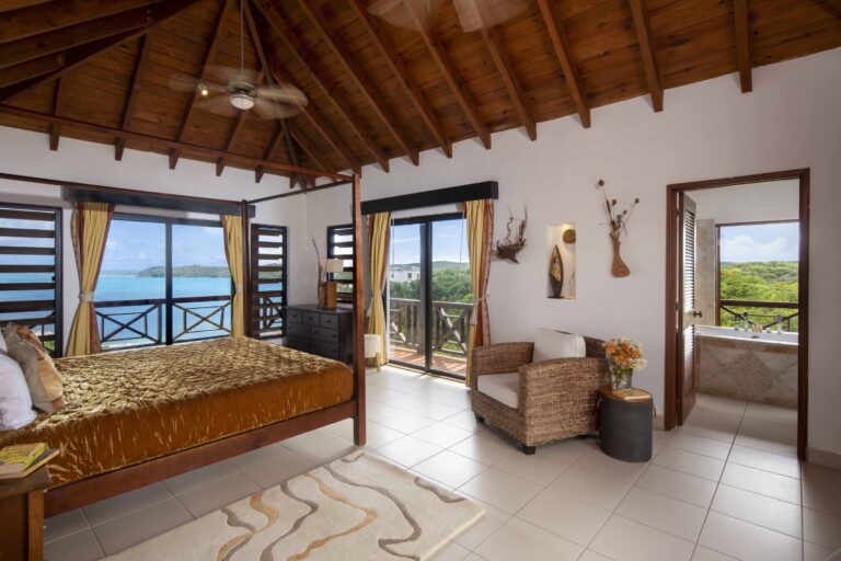 Bedroom with a gold bedspread and a window onto the water, Perfect Sunshine Antigua