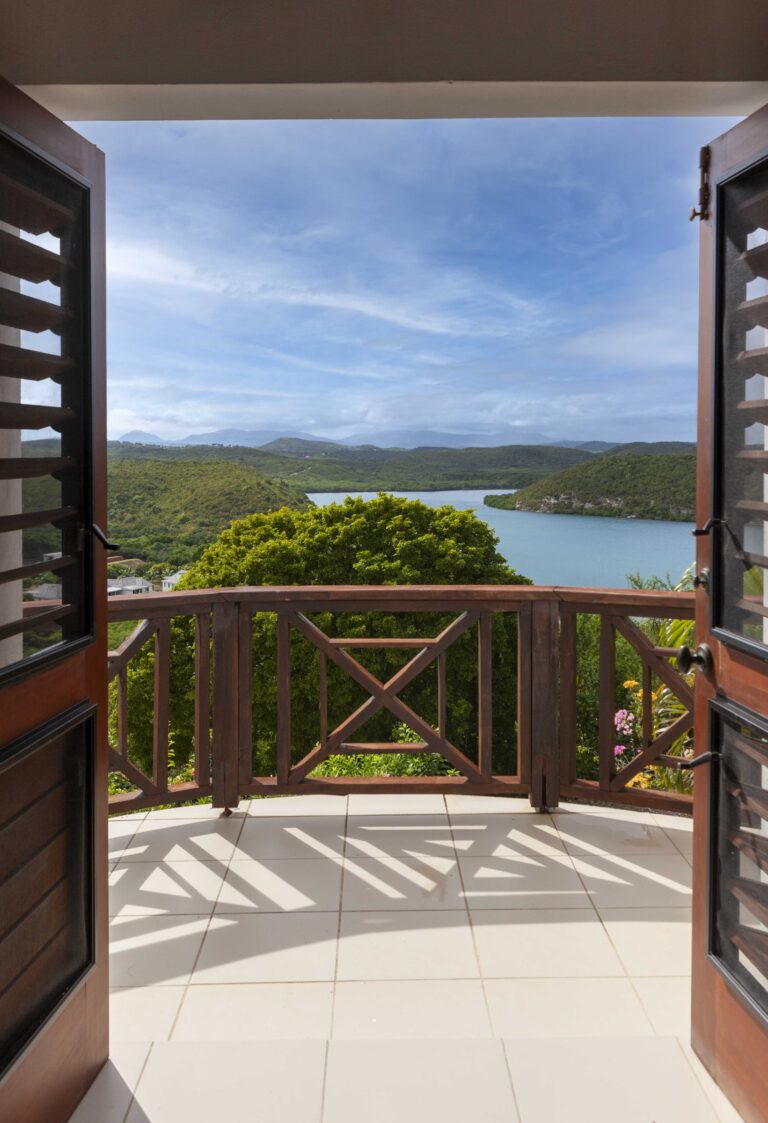 Open shuttered doors from a bedroom onto a balcony over the bay, Perfect Sunshine Antigua