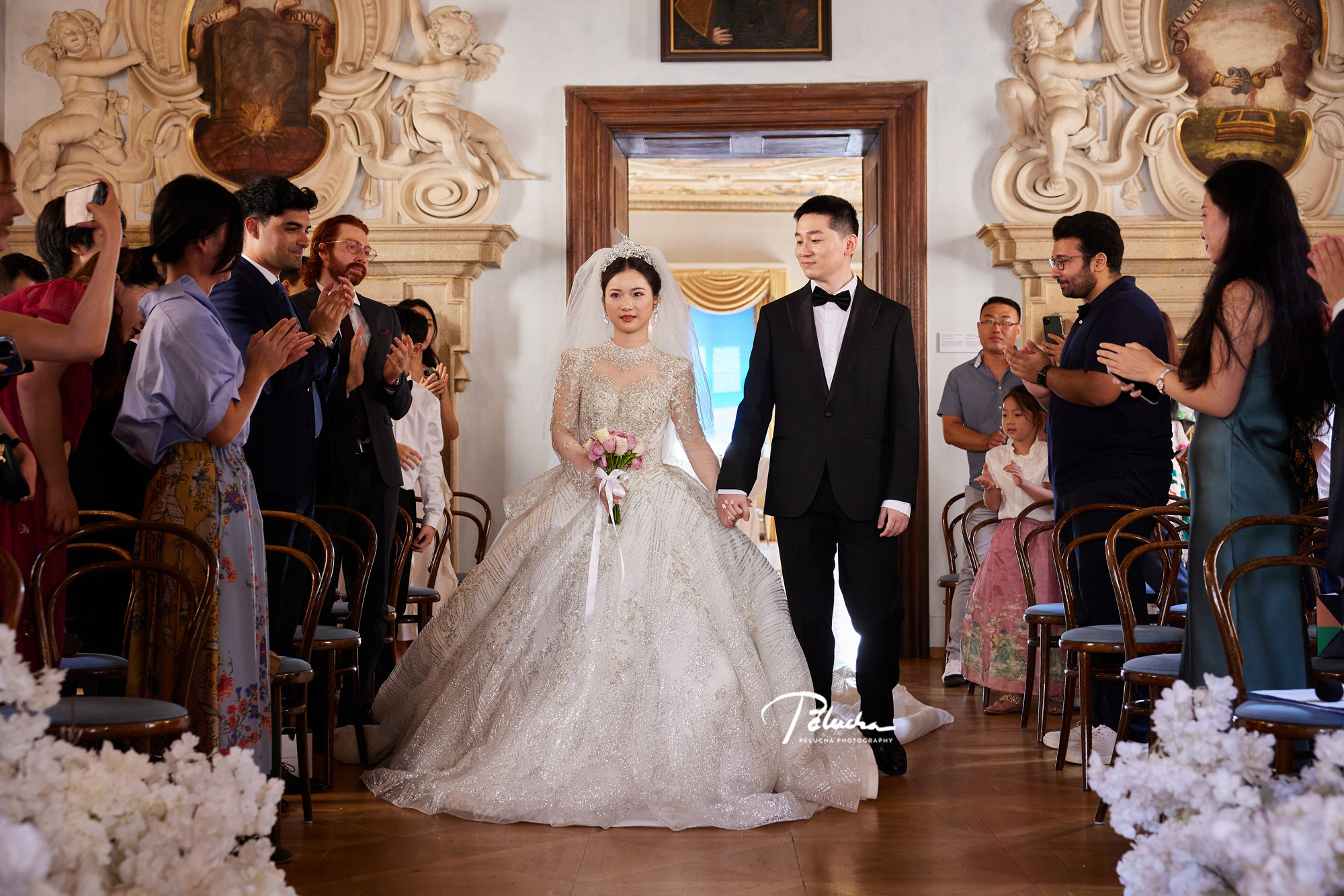 The couple walk back down the aisle after the ceremony, House of Lobkowicz, Prague, Petr Pelucha Photography