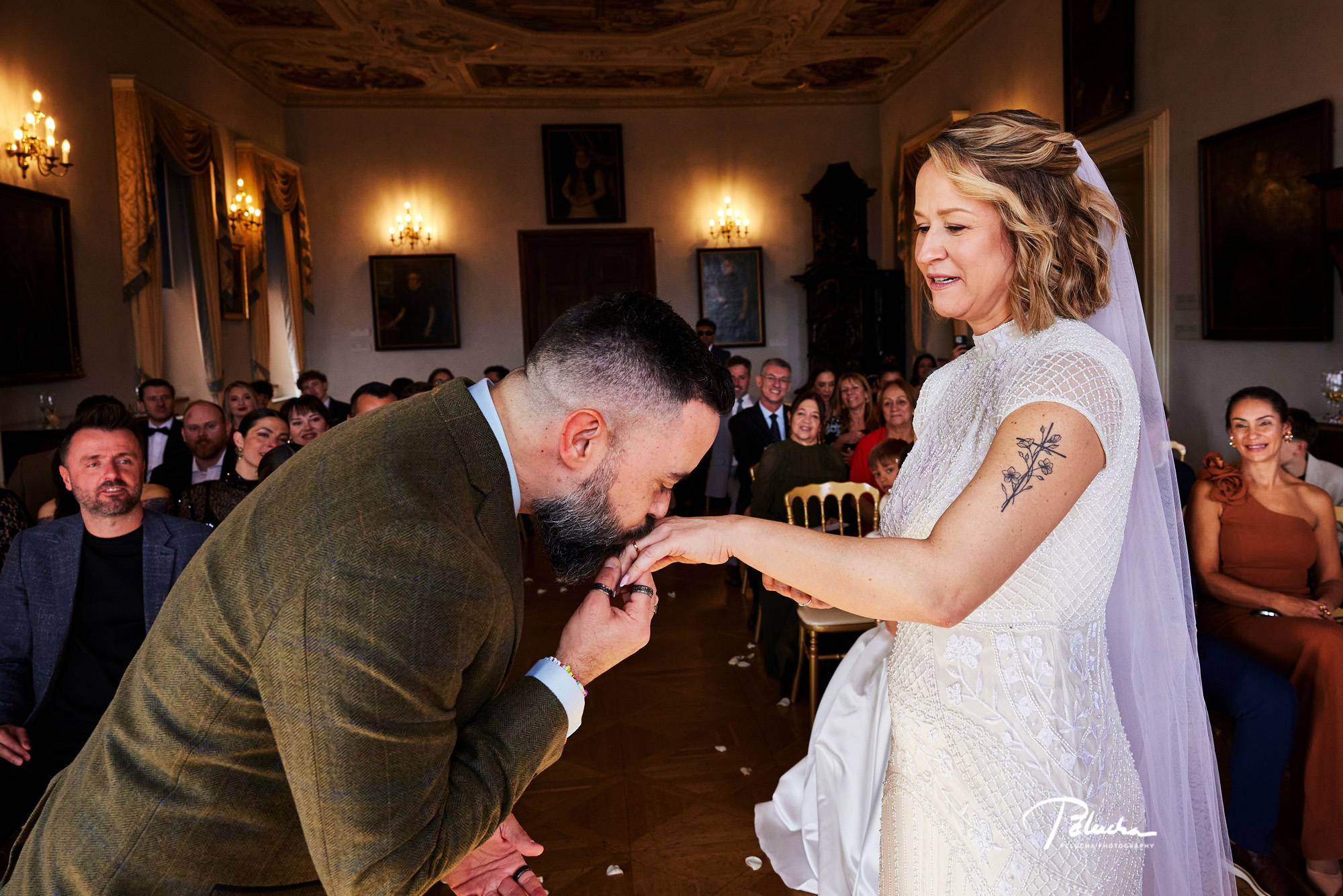 The groom kisses the bride's hand during a civil ceremony, House of Lobkowicz, Prague, Petr Pelucha Photography