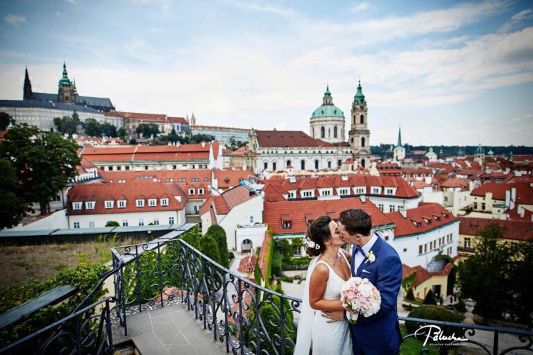 Couple kissing above the red roofs of Prague, with the Castle behind, Petr Pelucha Photography