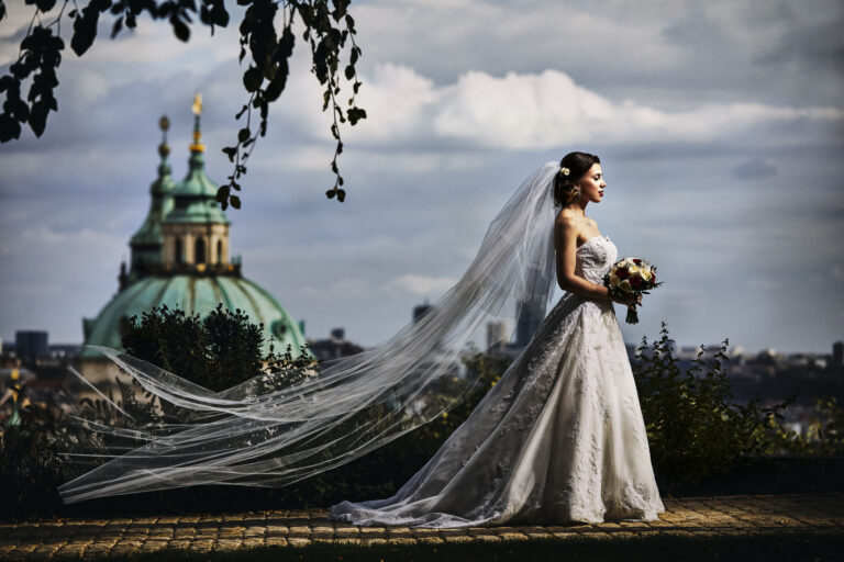 Bride with a long veil against a Prague dome and storm clouds, Petr Pelucha Photography