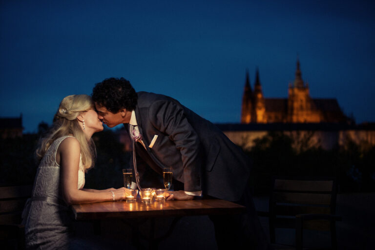 Candlelit table and a kiss with Prague Castle lit at night, Petr Pelucha Photography