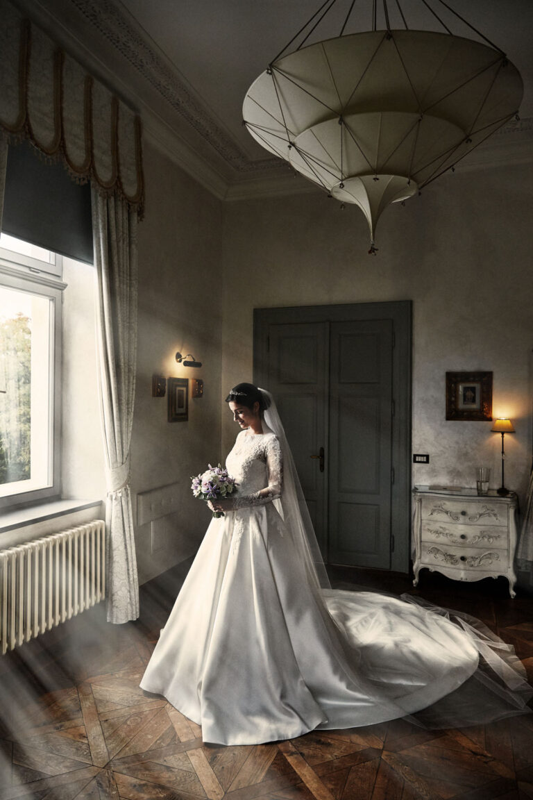 Bride in a satin gown in a softly lit room, Petr Pelucha Photography