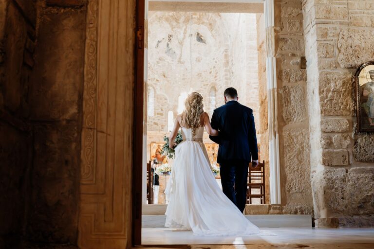 The bride and groom enter a stone church through its open doors, Photomad