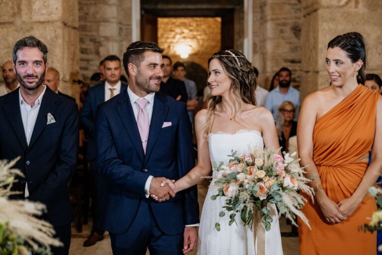 The couple stand hand in hand with guests during the ceremony, Photomad