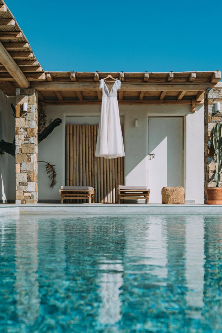 A wedding dress hanging beside a villa pool, Photomad
