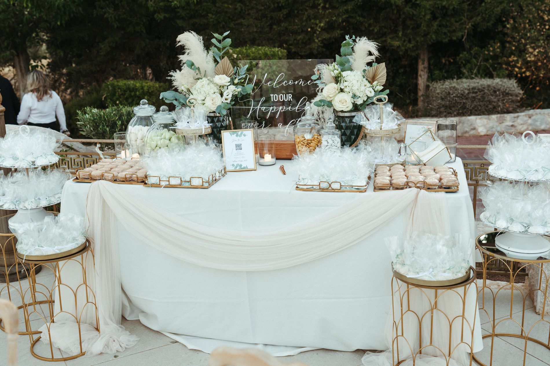 A white and gold dessert table with florals at the reception, Photomad