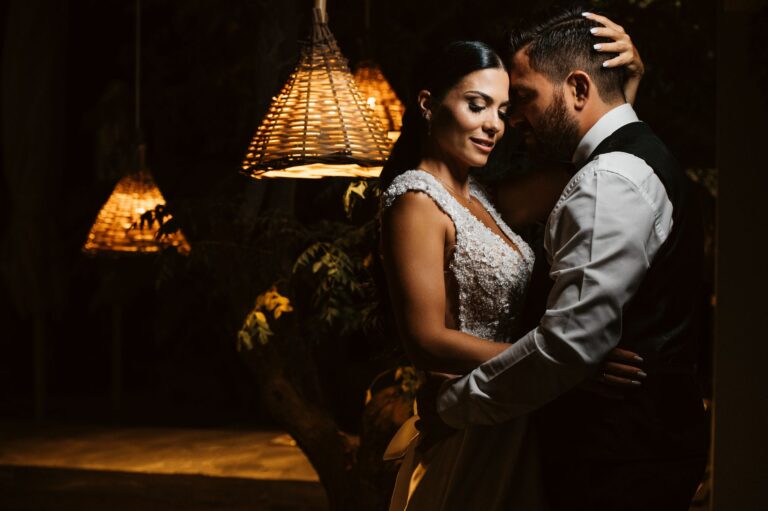 The couple dance close beneath woven lamps at the reception, Photomad