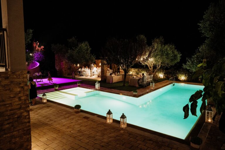 A lantern lit courtyard and illuminated pool at night, Photomad