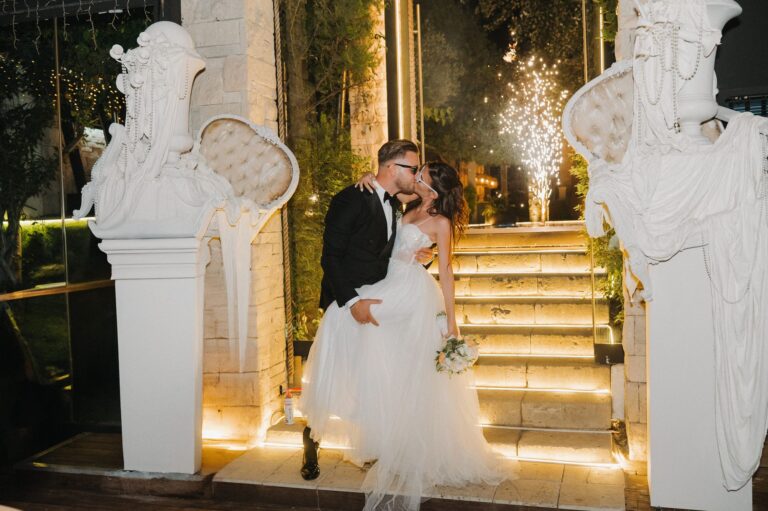 The couple on illuminated steps between white statues, Photomad