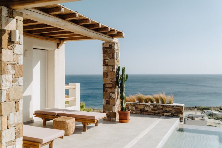A sunlit terrace with loungers and a sea view, Photomad