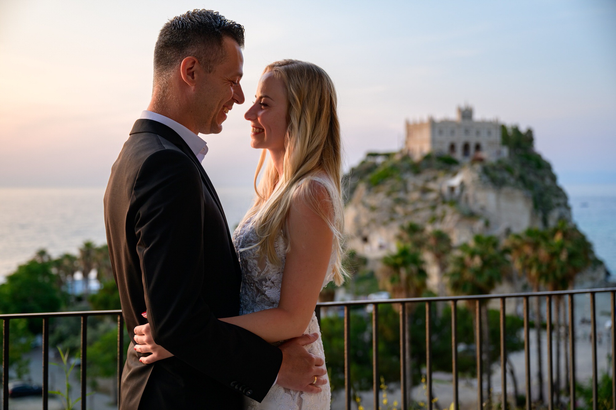 A couple at dusk with Santa Maria dell'Isola behind them, Tropea, Calabria, Pierpaolo Perri